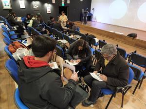 People sitting and working on worksheets during a hands-on session at the 5th Chilean Astronomy Education Conference