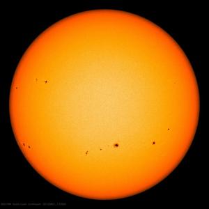 Image showing groups of sunspots as dark patches which lie in bands above and below the Sun's equator