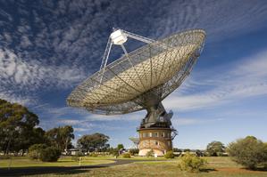 Panorama of the Parks Radio Telescope with blue sky and few thin clouds. The telescope looks like a giant satellite dish.