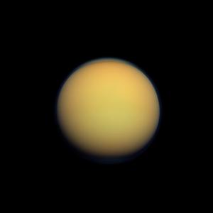 Titan, satellite de Saturne, dont l'atmosphère composée de nuages denses lui confère un aspect jaune orangé presque uniforme.