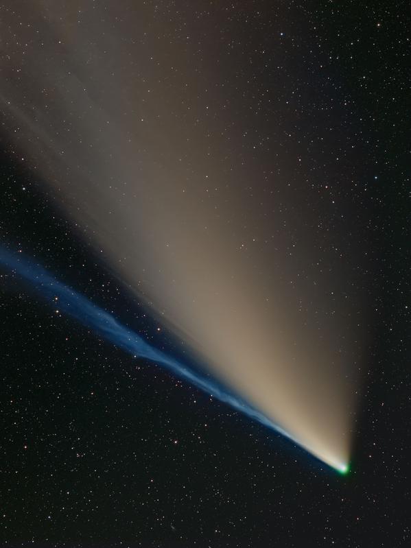 A comet with two tails, one is yellowish and gradually spreading away from the nucleus, the other is blue and compact