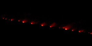 Comet Shoemaker–Levy 9 appears as a long chain of bright fragments against the dark background of space.