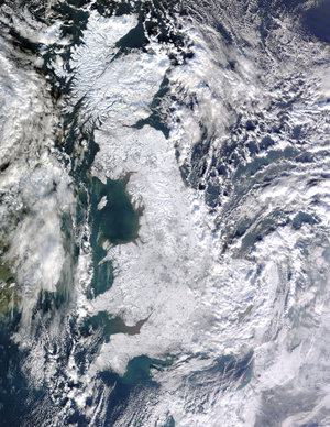 Great Britain is covered in white snow with small green gaps at the coast. Ireland is covered by patchy cloud but no snow