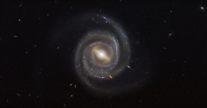 The central part of this galaxy is a fuzzy straight line with spiral arms extending from each end of that line.