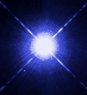 Sirius A, a bright star with x-shaped diffraction spikes. Sirius B is a faint dot to the lower left.