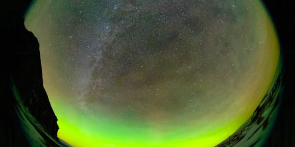 The sky rotates around one star that appears fixed. Bubbles and swirls of green aurorae fill the foreground