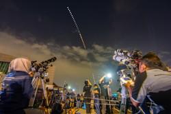 Deux astronomes observent une éclipse  lunaire. Entre eux, une série de cercles lumineux tracent une trajectoire courbe