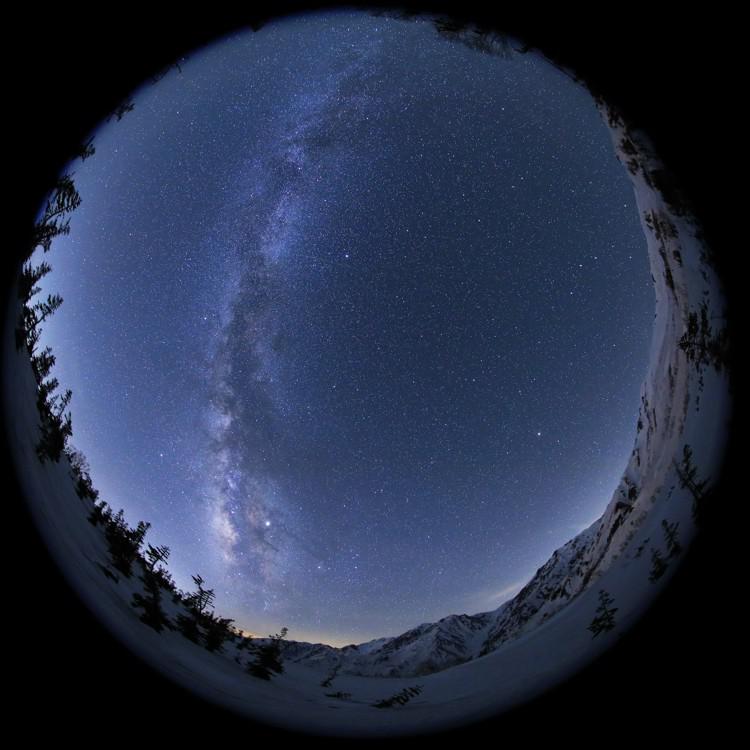 An all-sky image showing the Milky Way as a diffuse river of light, broken only by a mottled central band of dark patches